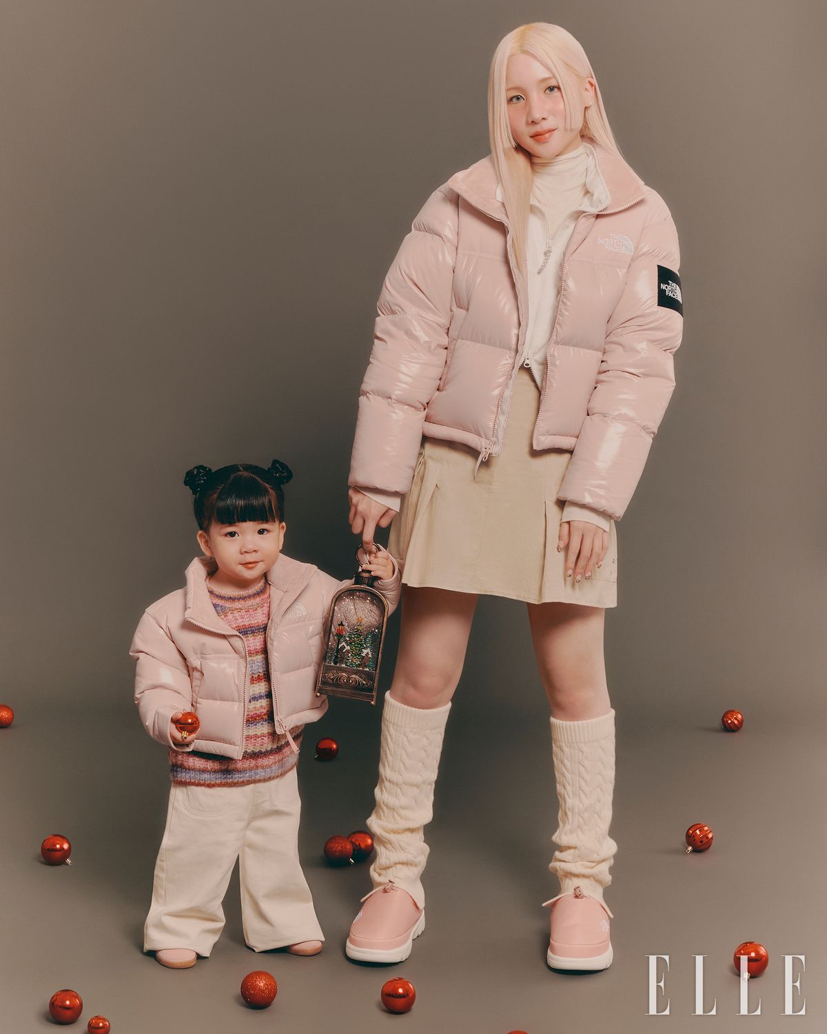 다솜이 착용한 노벨티 눕시 RDS 다운 재킷과 레그 워머, 캠프 뮬은 모두 The North Face. 터틀넥 톱은 스타일리스트 소장품. 레이어드한 재킷은 Spao. 스커트는 Sis A. 이로가 착용한 키즈 노벨티 눕시 RDS 다운 재킷은 The North Face. 톱과 팬츠, 슈즈는 모두 Zara.