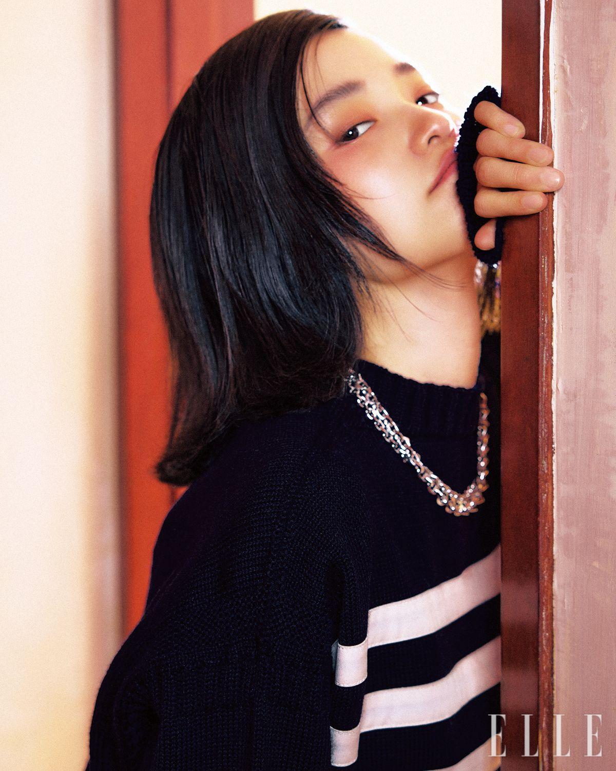 스트라이프 디테일의 스웨터는 Prada. 이터널 골드 체인 네크리스는 Prada Fine Jewelry.