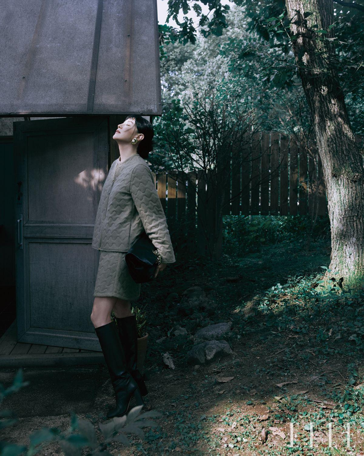 웨이브 라인을 따라 퀼팅을 더한 재킷과 스커트, 볼드한 이어링, 나파 레더 아일릿 백과 하이힐 부츠는 모두 Fabiana Filippi.