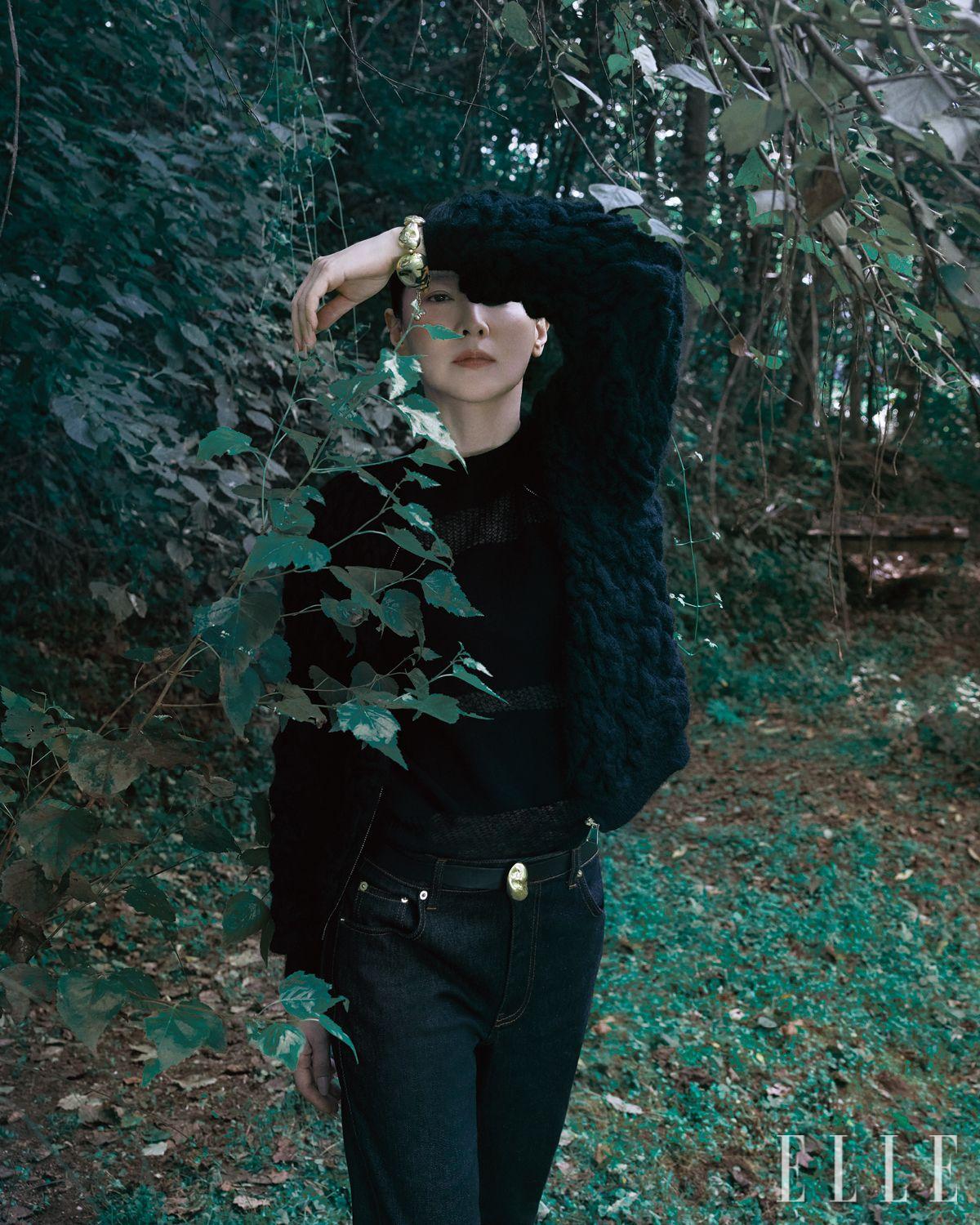 풍성한 모헤어 소재의 블랙 카디건과 스트라이프 패턴 시스루 스웨터, 데님 팬츠, 너깃 장식의 레더 벨트와 브레이슬릿은 모두 Fabiana Filippi.