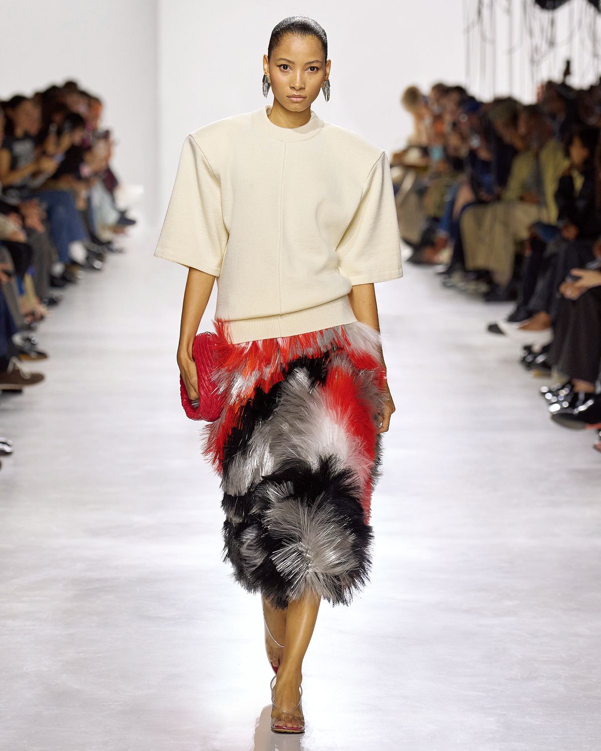 넓은 어깨와 찰랑이는 프린지 장식으로 존재감 있는 여성의 실루엣을 표현한 루이스 트로터. 