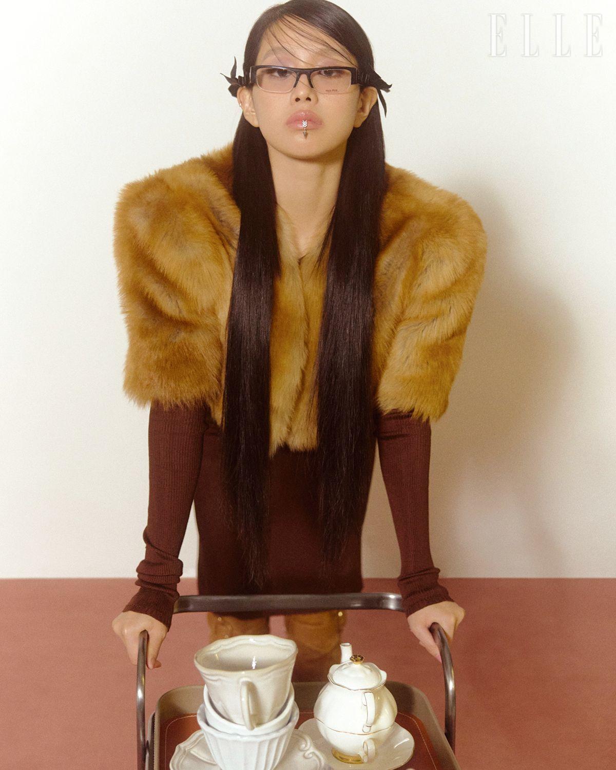 크롭트 퍼 재킷과 니트 톱, 스커트, 브라운 부츠, 안경은 모두 Miu Miu. 립 커프는 Uselessobjects. 보 헤어핀은 스타일리스트 소장품.