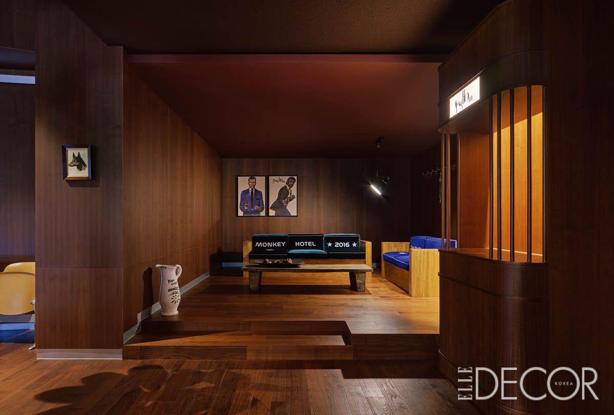 1960~1970년대 호텔 라운지나 재즈 바를 연상시키는 레트로 무드의 공간. 굵직한 구조선과 따뜻한 조명, 블루 패브릭 벤치의 대비가 인상적이다.