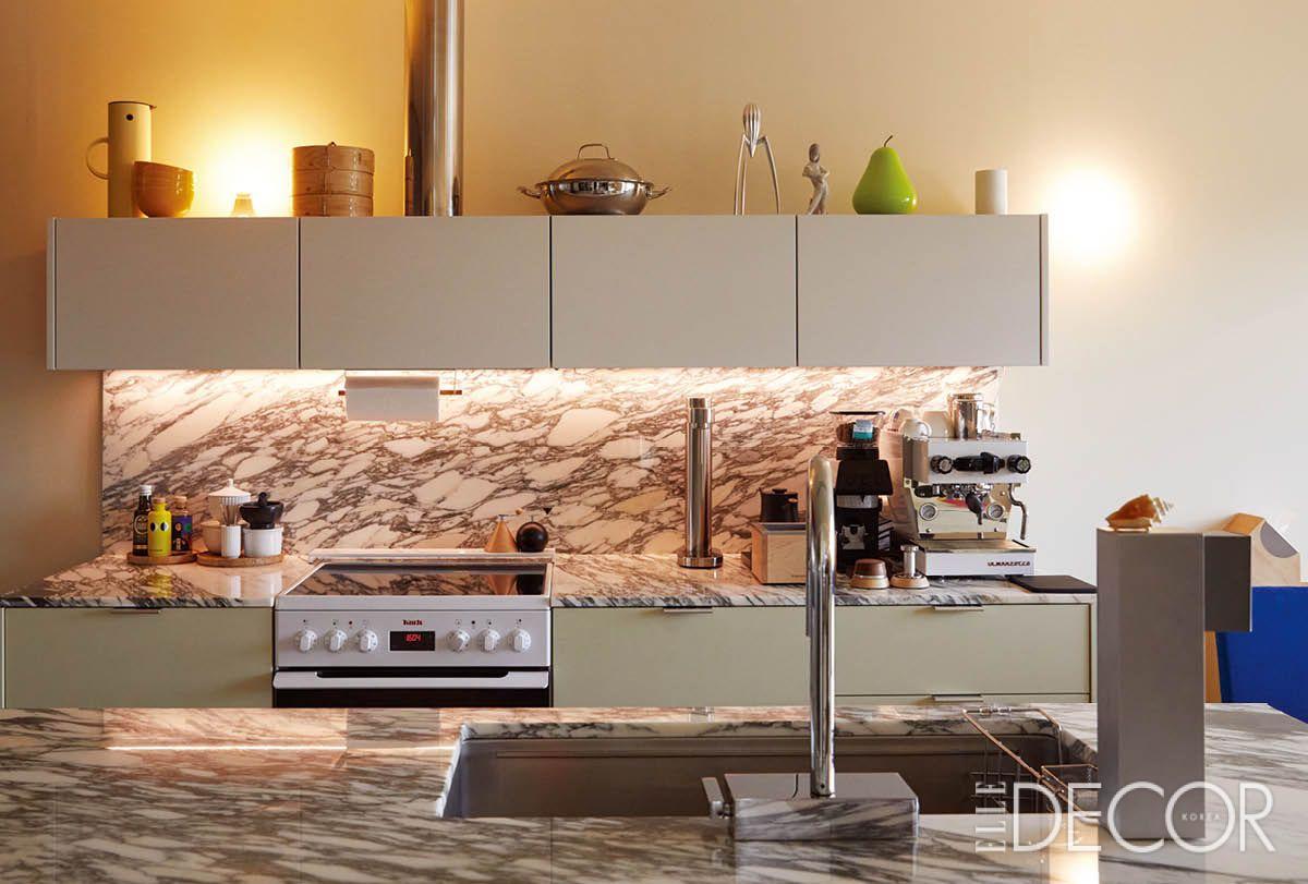 키친 디자인 스튜디오 MMK에 의뢰해 제작한 주방. 진한 패턴의 천연 대리석으로 마감했다. 컴팩트하게 구성한 상부장에는 그간 모아온 크고 작은 물건을 올려 장식했다.