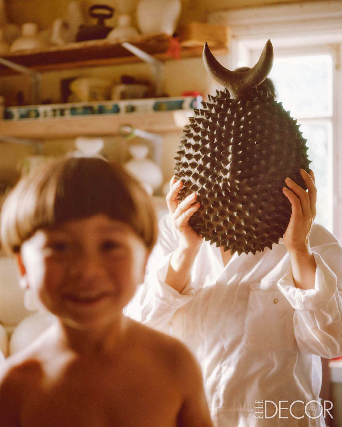 오니 가면에서 영감받은 ‘섀도’ 시리즈를 들고 있는 노에 쿠레모토와 그의 아들.