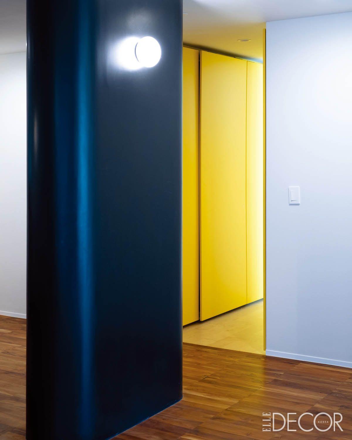 노란색을 중심으로 붙박이 가구를 제작하고, 거실 창가에는 다양하게 활용 가능한 단을 만들었다. 짙은 네이비 벽과 발랄한 옐로 컬러의 수납장이 만드는 대비가 흥미로운 공간은 식스티세컨즈 김한정 실장의 집.