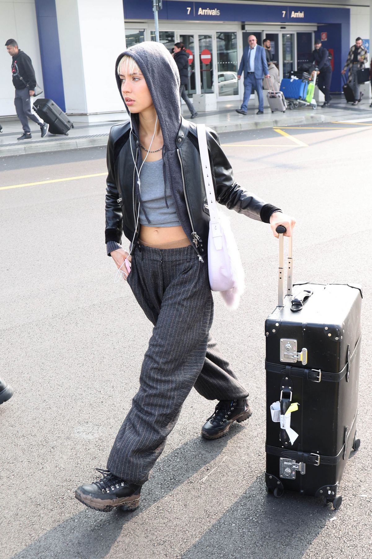 아이리스 로는 투박한 가죽 스트랩과 금속 장식이 돋보이는 클래식한 블랙 트렁크로 자유분방한 그런지 룩에 시크한 무게감을 더했습니다.