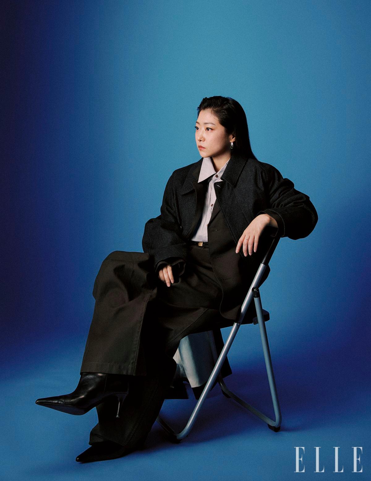 코트와 수트 세트업, 셔츠와 레더 벨트는 모두 Lemaire. 이어링은 Cos. 부츠는 스타일리스트 소장품.