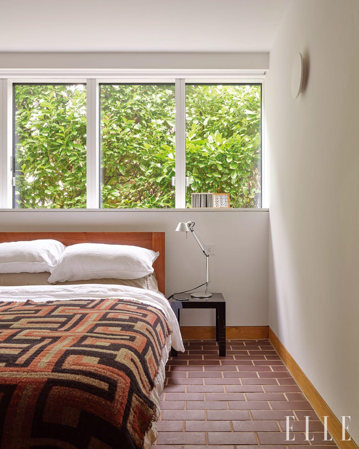 데 라 에스파다(De La Espada)의 침대와 아르테미데 톨로메오(Tolomeo) 등을 둔 게스트 침실. 