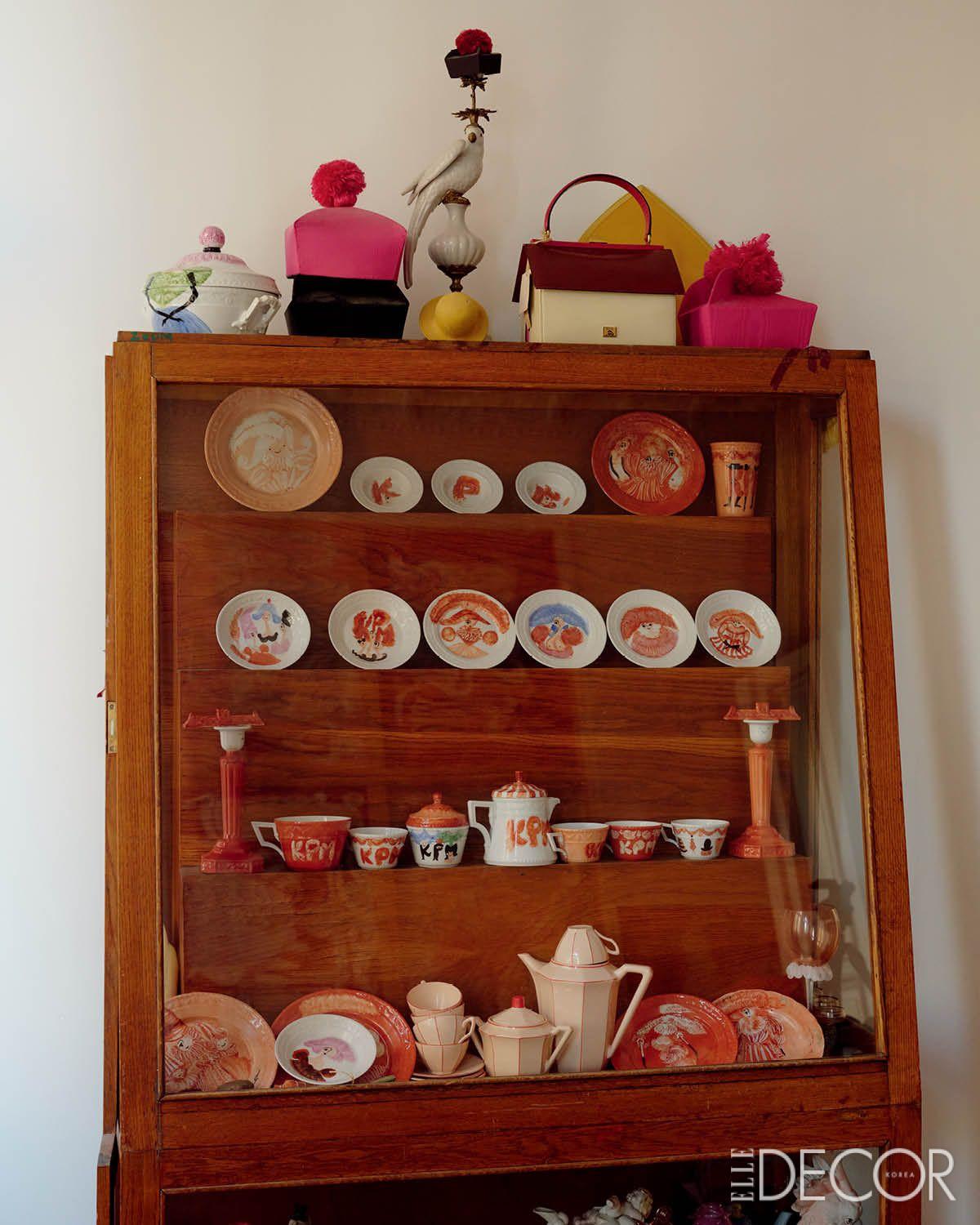  직접 그림을 그려 장식한 접시들이 모여 있는 빈티지 수납장. 