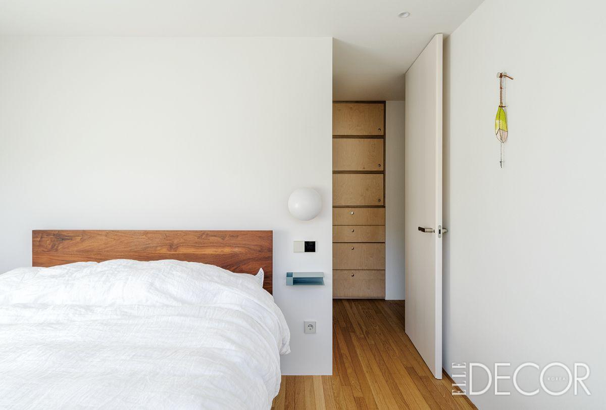 창가에는 아끼는 공예품들을 나란히 배치했다. 우드 소재로 마감한 헤드 보드의 침대가 담백한 분위기의 침실과 어우러진다.