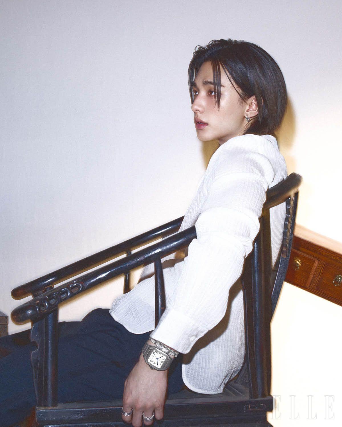 화이트골드에 브릴리언트 컷 다이아몬드를 세미 파베 세팅한 LOVE 이어링, 스틸 브레이슬릿의 산토스 드 까르띠에 워치, 화이트골드 클래쉬 드 까르띠에 스몰 브레이슬릿, 화이트골드에 브릴리언트 컷 다이아몬드를 파베 세팅한 LOVE 브레이슬릿, 검지에 착용한 화이트골드 클래쉬 드 까르띠에 더블 로우 링, 약지에 착용한 화이트골드에 브릴리언트 컷 다이아몬드를 파베 세팅한 클래쉬 드 까르띠에 링, 레이어드한 화이트골드 LOVE 언리미티드 링은 모두 Cartier. 랩 셔츠는 Ann Demeulemeester by Boontheshop. 팬츠는 Amiri.