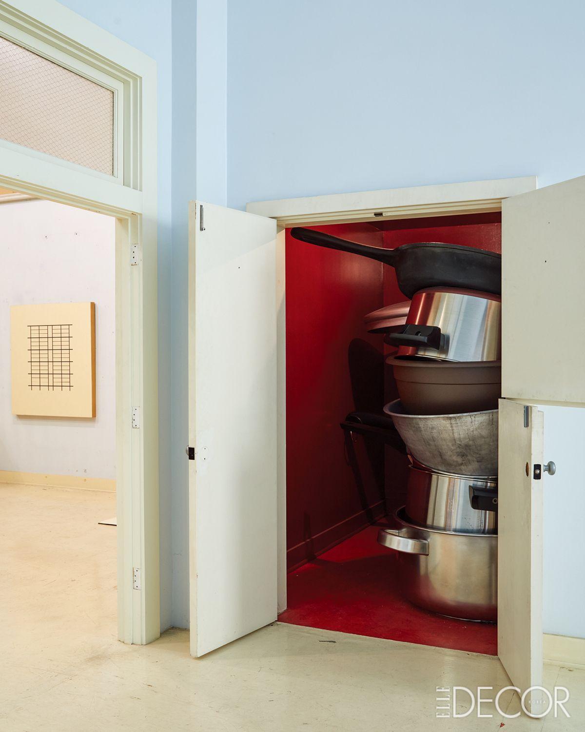 열린 문 사이로 강렬한 붉은색과 겹겹이 쌓인 주방 용품들이 시선을 붙잡는다. 테리엔이 평생을 바쳐 탐구한 수학적 질서와 일상의 경이로움 사이의 긴장감을 볼 수 있는 장면.