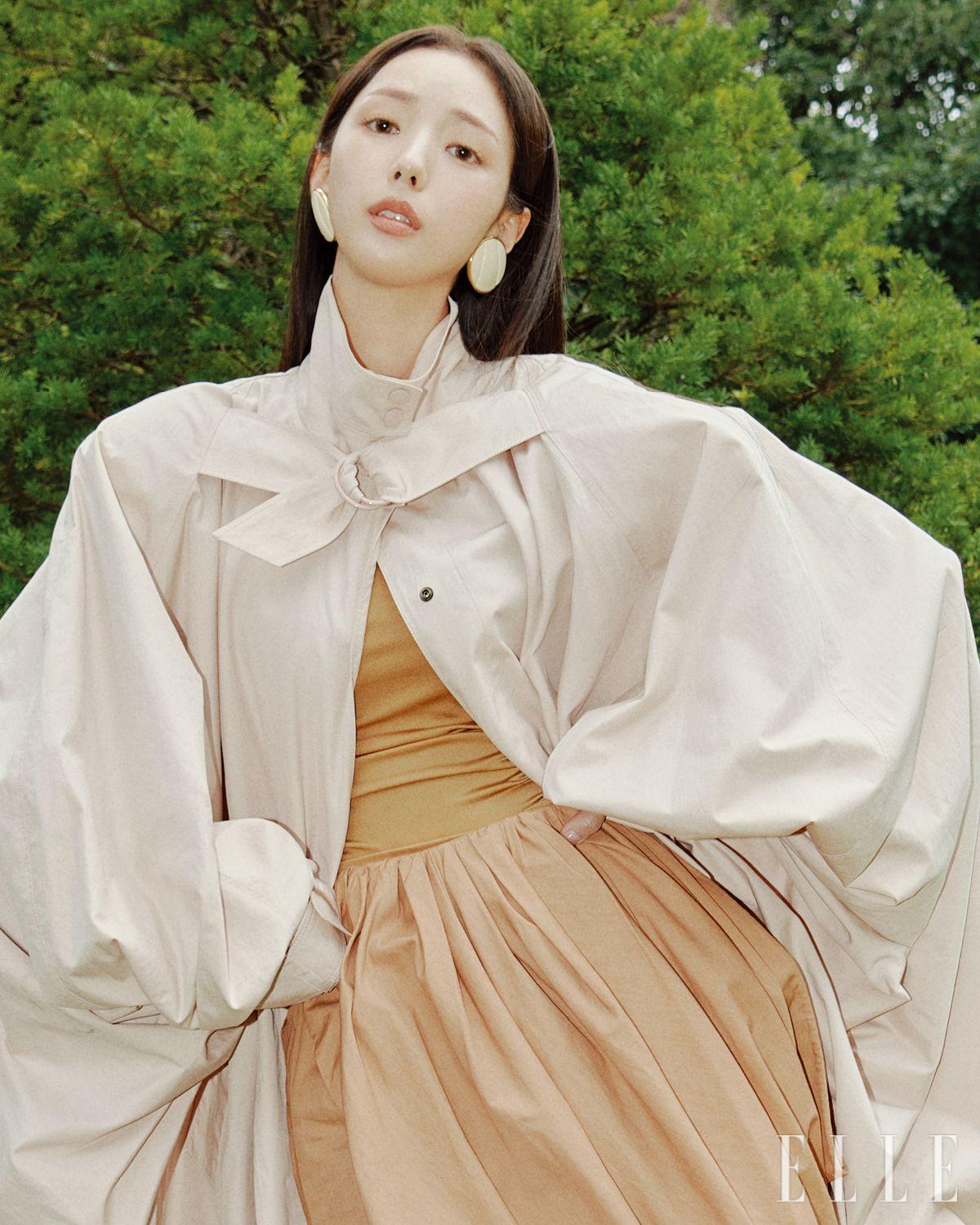 트렌치코트와 보디수트, 드레이핑 스커트, 원형 이어링과 젤리 슈즈는 모두 Chloé.