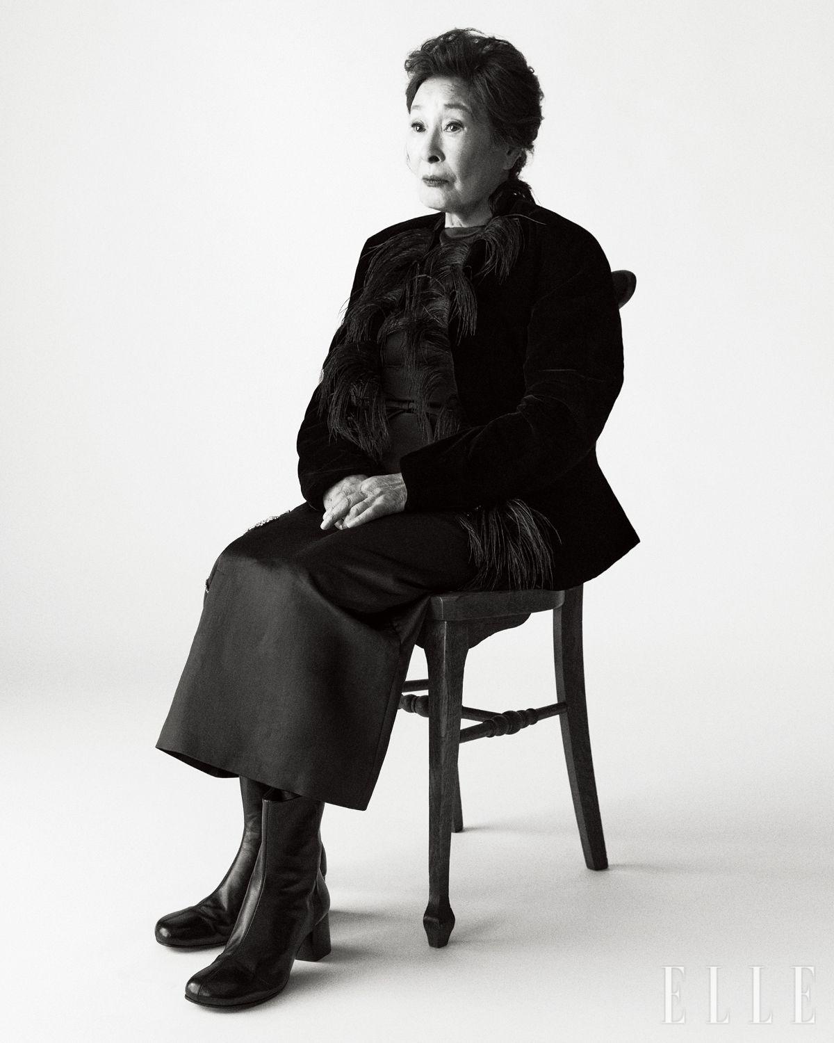 페더 디테일의 벨벳 재킷은 The Row. 새틴 드레스는 Erdem. 앵클부츠는 Lemaire. 왼쪽 귀에 착용한 여섯 개의 페어 컷 다이아몬드를 세팅한 ‘세르티 수르 비드’ 이어 커프는 Repossi.