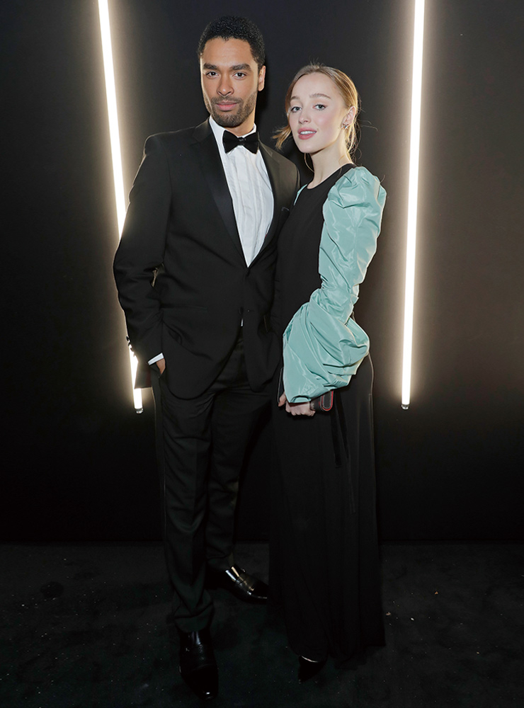 다프네의 시그너처 컬러인 블루와 공작처럼 어깨 라인을 강조한 룩을 입고 포토 월에서 다정하게 포즈를 취한 두 사람.