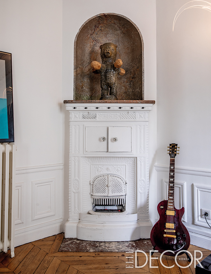 로랑 뒤푸르(Laurent Dufour)의 세라믹 작품과 베누아의 전자 기타가 절묘하게 어울리는 다이닝 룸 코너의 벽난로 풍경.