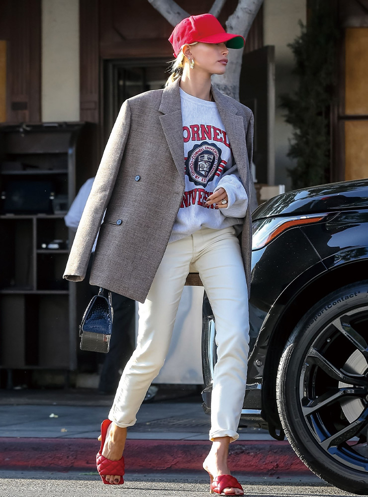 원 마일 웨어 트렌드를 이끌며 다양한 아이템을 유행시킨 헤일리 비버는 간결한 블레이저에 90년대 무드의 클래식 로고 스웨트셔츠를 매치했다. 레드 볼 캡으로 컬러 포인트를 더해 이목을 집중시켰다.