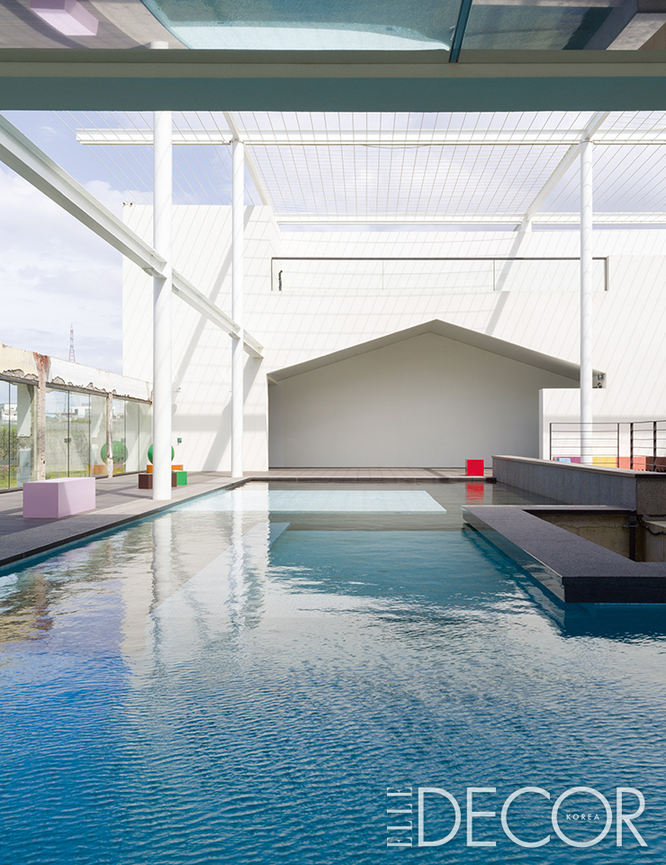 렘 콜하스 OMA 출신의 네델란드 건축 디자인 그룹 MVRDV의 장난감 같은 조각 작품이 벤치와 테이블을 대신하는 야외 수영장.