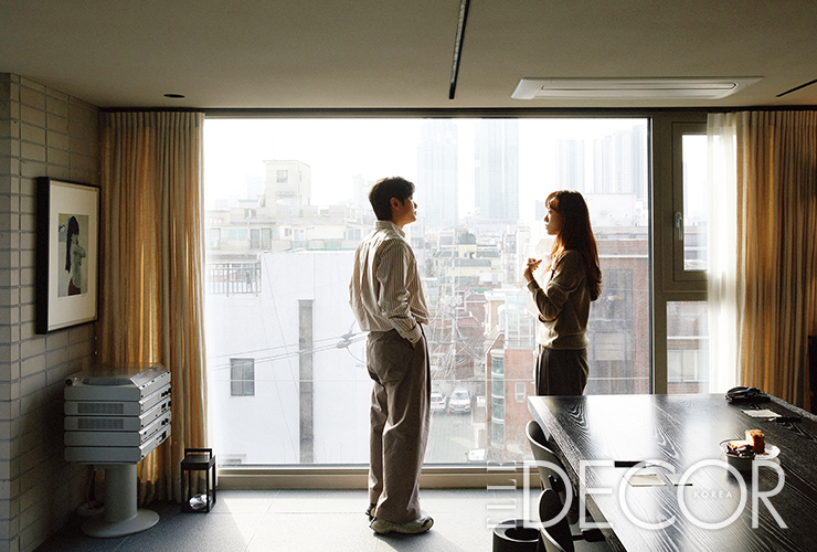 전망 좋은 6층 회의실 창문 앞에서 이야기를 나누는 고정석 · 홍정희 소장.