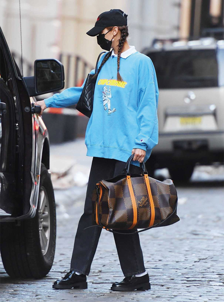 선명한 스카이 블루 스웨트셔츠를 선택한 벨라 하디드. 넉넉한 실루엣의 팬츠와 빅 사이즈 토트백을 매치한 센스에 주목! 
